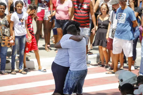 Os pais da menina se emocionam durante oração em frente ao cemitério