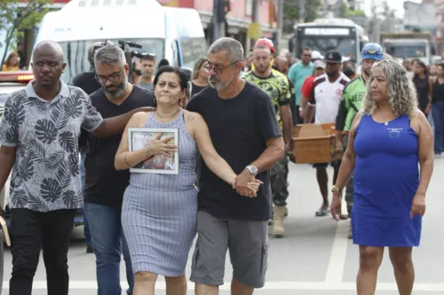 Irmã de Allan acompanha cortejo com foto de dele junto com Rosilene e Maitê durante cortejo