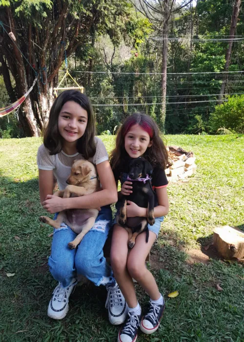 Maya e sua prima com animais resgatados de rua