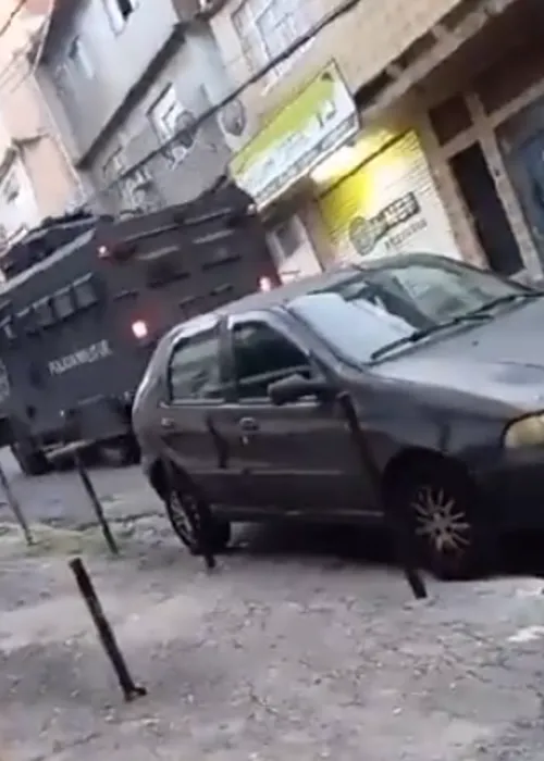 Moradores registram a entrada do veículo blindado da polícia