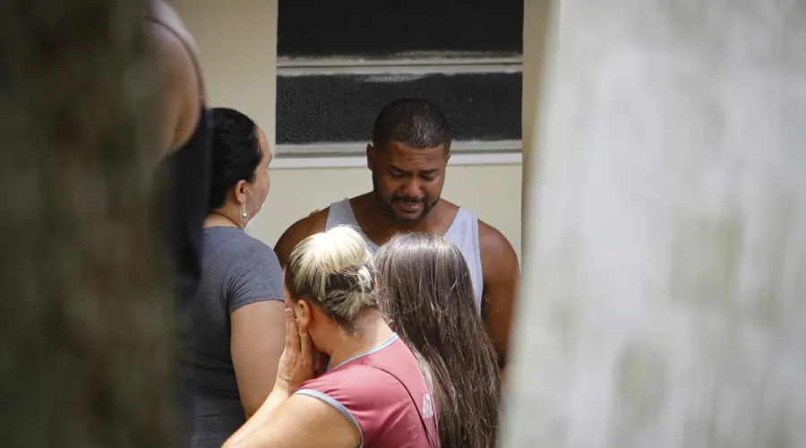 O marido de Juliana e pai de Caio, Erick Pereira, é consolado por parentes e amigos no enterro