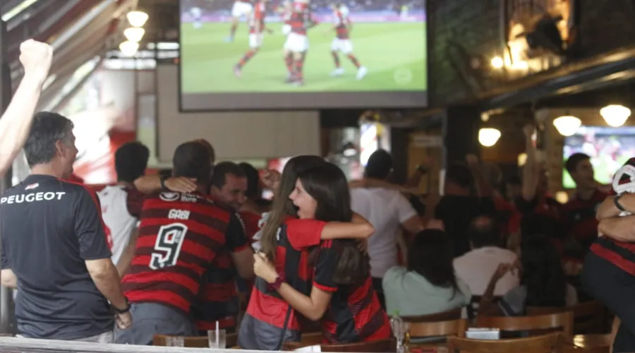 Torcedores reunidos em bar de Niterói se abraçam depois do gol de Pedro