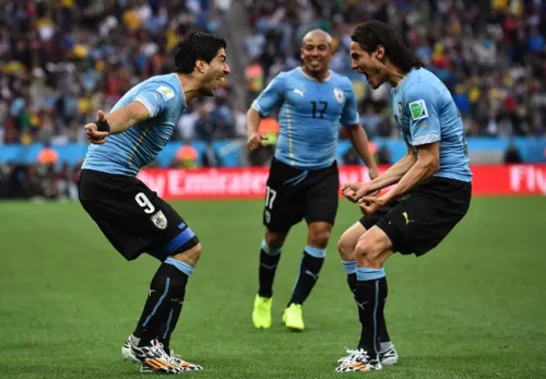 Uruguay's forward Luis Suarez (L) celebrates scoring with teammates Uruguay's forward Edinson Cavani (R) and Uruguay's midfielder Egidio Arevalo Rios (C) during the Group D football match between Uruguay and England at the Corinthians Arena in Sao Paulo on June 19, 2014, during the 2014 FIFA World Cup. AFP PHOTO / BEN STANSALL