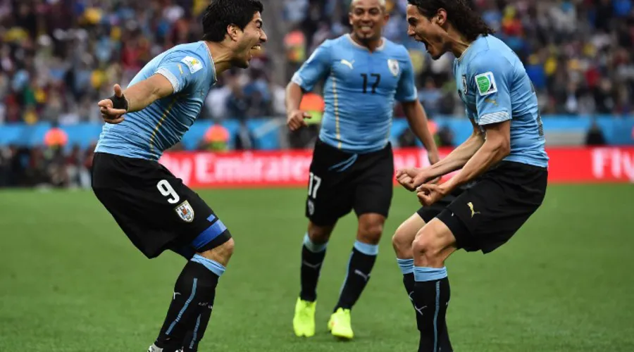 Uruguay's forward Luis Suarez (L) celebrates scoring with teammates Uruguay's forward Edinson Cavani (R) and Uruguay's midfielder Egidio Arevalo Rios (C) during the Group D football match between Uruguay and England at the Corinthians Arena in Sao Paulo on June 19, 2014, during the 2014 FIFA World Cup. AFP PHOTO / BEN STANSALL